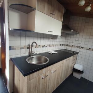 a kitchen with a sink and a black counter top at Apartments Obala in Malinska