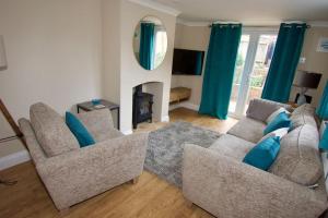 a living room with two couches and a fireplace at Cottage in Framlingham in Framlingham