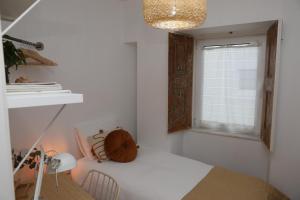 a bedroom with a bed and a window at Casa Rosas do Mondego in Figueira da Foz