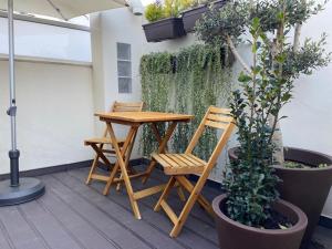 a wooden table and chairs on a patio with plants at Casa Rosas do Mondego in Figueira da Foz