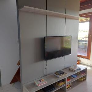 een flatscreen-tv aan een muur in een woonkamer bij Casa Bouganville in Monte das Gameleiras
