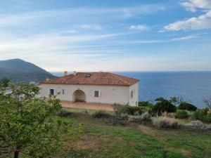 une maison blanche avec vue sur l'océan dans l'établissement Villa Saint-Michel, à Galéria