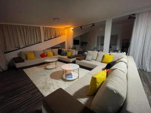 ein Wohnzimmer mit einer weißen Couch und gelben Kissen in der Unterkunft House of Art in Braşov