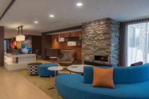 a living room with a blue couch and a fireplace at Fairfield Inn & Suites by Marriott Gaylord in Gaylord