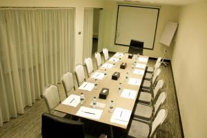 Business Inn Olaya في الرياض: قاعة المؤتمرات مع طاولة وكراسي طويلة