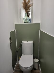 La salle de bains est pourvue de toilettes et d'un vase. dans l'établissement Perle rare acces direct a la plage, à Mauguio