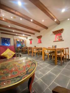 a dining room with tables and chairs and a table at Three Jewels Boutique Hotel in Pokhara