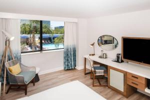 a hotel room with a desk and a tv and a window at Renaissance Newport Beach Hotel in Newport Beach