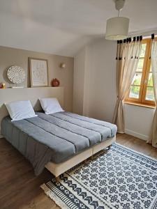 a bedroom with a large bed with a rug and a window at Maison de vacances à la campagne in Boisset