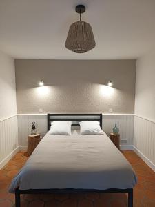 a bedroom with a large bed and a pendant light at Maison de vacances à la campagne in Boisset