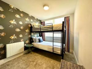a bedroom with two bunk beds in a room at Stunning 2 bedroom Apartment inc Free Parking - 1 Minute walk to Poole Quay - Great Location - Free Parking - Fast WiFi - Smart TV - Newly decorated - sleeps up to 4 - Close to Poole & Bournemouth & Sandbanks in Poole