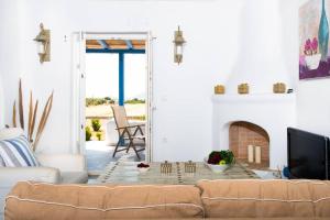a living room with a couch and a fireplace at Pergola Paros Cycladic House by the Sea+Pool in Naousa