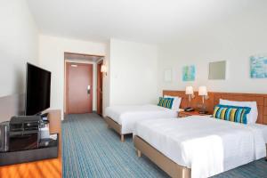 a hotel room with two beds and a flat screen tv at Courtyard By Marriott Brussels in Brussels