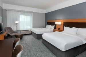 a hotel room with two beds and a television at TownePlace Suites Buffalo Airport in Cheektowaga