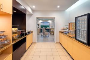 a restaurant with a food counter and a dining room at TownePlace Suites Buffalo Airport in Cheektowaga