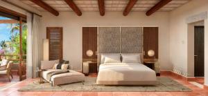 um quarto com uma cama, um sofá e uma cadeira em The St. Regis Punta Mita Resort em Punta Mita
