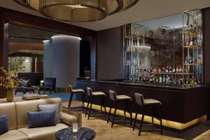 a bar in a hotel with a couch and chairs at The Ritz-Carlton Jakarta, Pacific Place in Jakarta