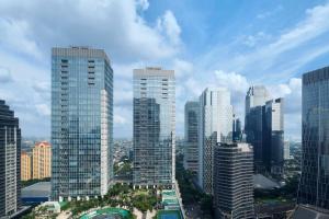 um grupo de edifícios altos em uma cidade em The Ritz-Carlton Jakarta, Pacific Place em Jakarta