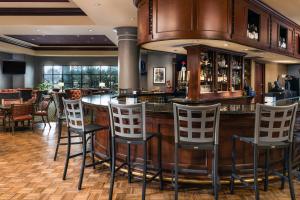 a bar in a restaurant with bar stools at Renaissance Tulsa Hotel & Convention Center in Tulsa