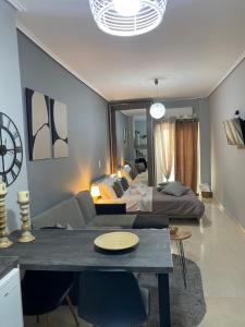 ein Wohnzimmer mit einem Sofa und einem Bett in der Unterkunft on the square studio in Kalamata