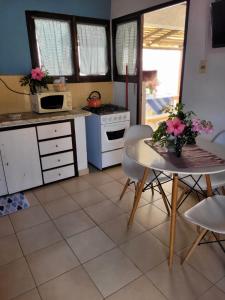 a kitchen with a table with flowers on it at Cabañas Virazon Aguas Dulces in Aguas Dulces