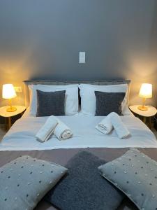 a large bed with two pillows and two lamps at on the square studio in Kalamata