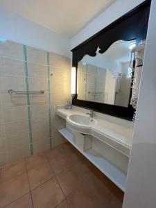 La salle de bains est pourvue d'un lavabo et d'un miroir. dans l'établissement Le Laïlana, à Sainte-Anne