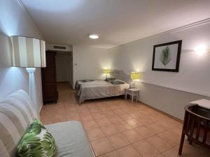 a bedroom with a bed and a couch in a room at Le Laïlana in Sainte-Anne