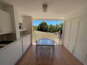 a kitchen with a table on a balcony at Le Laïlana in Sainte-Anne