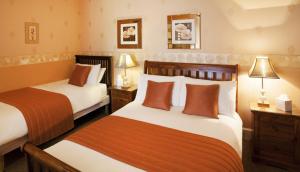 a hotel room with two beds and two lamps at Roseneath Guest House in Inverness