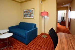 sala de estar con silla azul y mesa en Fairfield Inn and Suites by Marriott Winston Salem/Hanes, en Winston-Salem