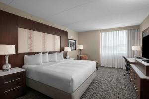 a hotel room with a large bed and a desk at Pittsburgh Marriott North in Cranberry Township