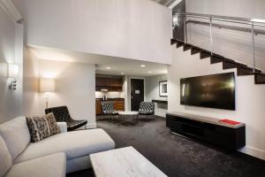 a living room with a couch and a flat screen tv at Ambassador Hotel Kansas City, Autograph Collection in Kansas City