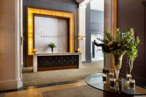 eine Lobby mit einem Glastisch und einem Spiegel in der Unterkunft Ambassador Hotel Kansas City, Autograph Collection in Kansas City
