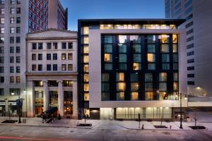 a large building in a city with tall buildings at Ambassador Hotel Kansas City, Autograph Collection in Kansas City