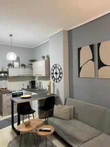 a living room with a couch and a table and a kitchen at on the square studio in Kalamata