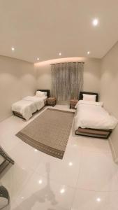 een slaapkamer met 2 bedden en een raam bij نزل ليلى الفندقية الفاخرة luxury in Abha