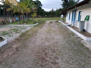 un chemin de terre à côté d'une maison plantée de palmiers dans l'établissement RESIDENCE VERO, à Matoury