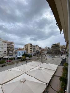 a group of white umbrellas on a city street at on the square studio in Kalamata