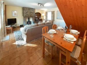 a living room with a table and a couch at Beck Cottage in Ennerdale Bridge