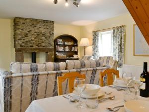a dining room with a table and a couch at Beck Cottage in Ennerdale Bridge