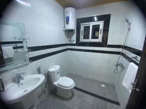 a bathroom with a white toilet and a sink at Hôtel rotana in Brazzaville