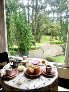 a table with plates of food and a window at Privilege Apart hotel Mountain Village in Canela