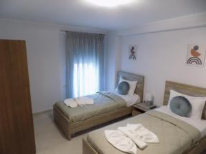 a bedroom with two beds and a window at elzaf1 in Afitos