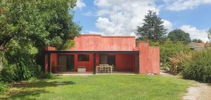 una casa roja con un patio delante en Casa del Correo en Duggan