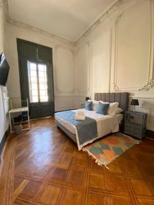 a bedroom with a bed and a wooden floor at Casa Marina Huérfanos in Santiago