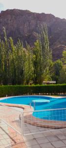 a large blue swimming pool with a mountain in the background at Cabañas Del Sol in Valle Grande