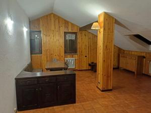 a large kitchen with a sink and wooden walls at Mansarda in Morgex