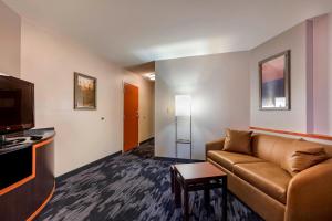 a living room with a couch and a flat screen tv at Fairfield Inn & Suites Columbus in Columbus