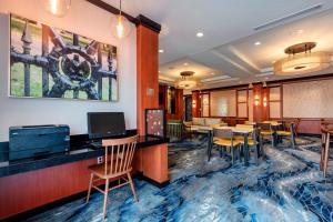 Fairfield Inn & Suites Columbus في كولومبوس: لوبي الفندق مع بار وطاولات وكراسي